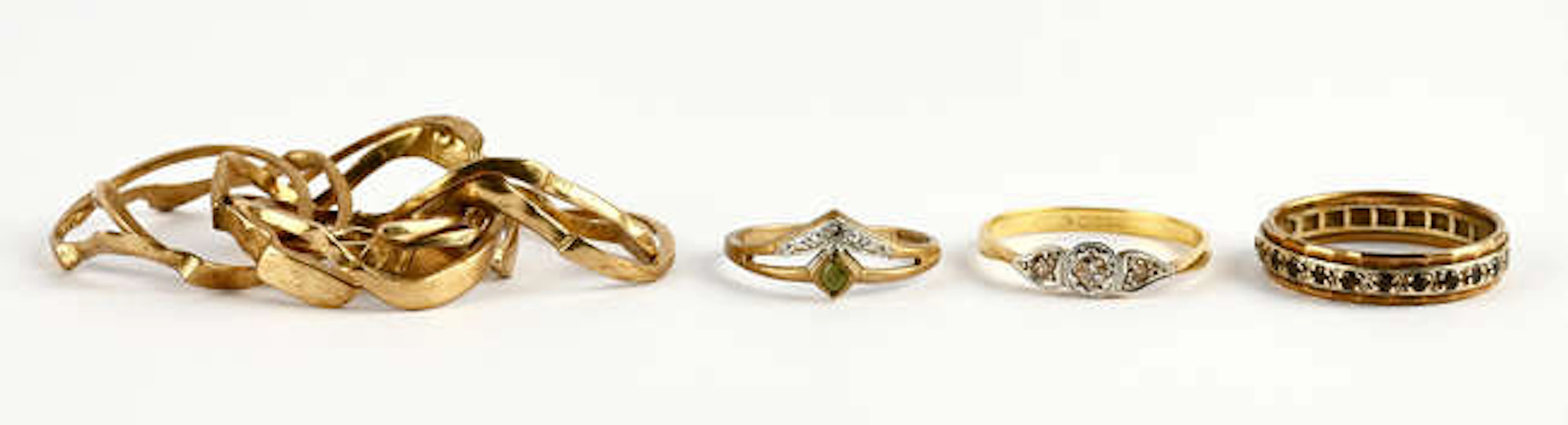 A group of rings, including a three stone diamond ring set with round