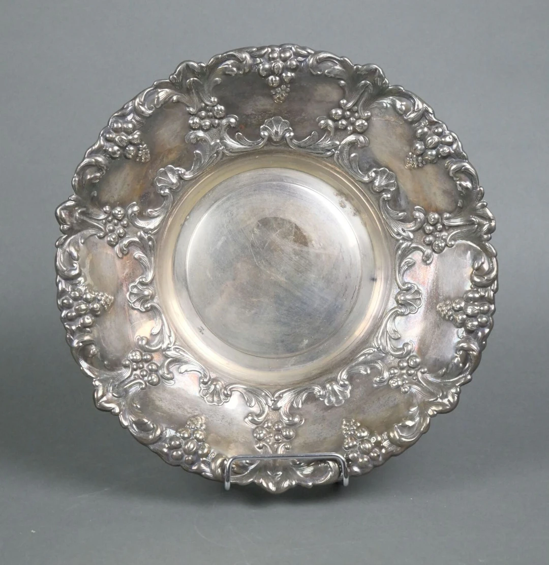 A circular silver plated metal bowl with rich chiseled and r - Lot 132