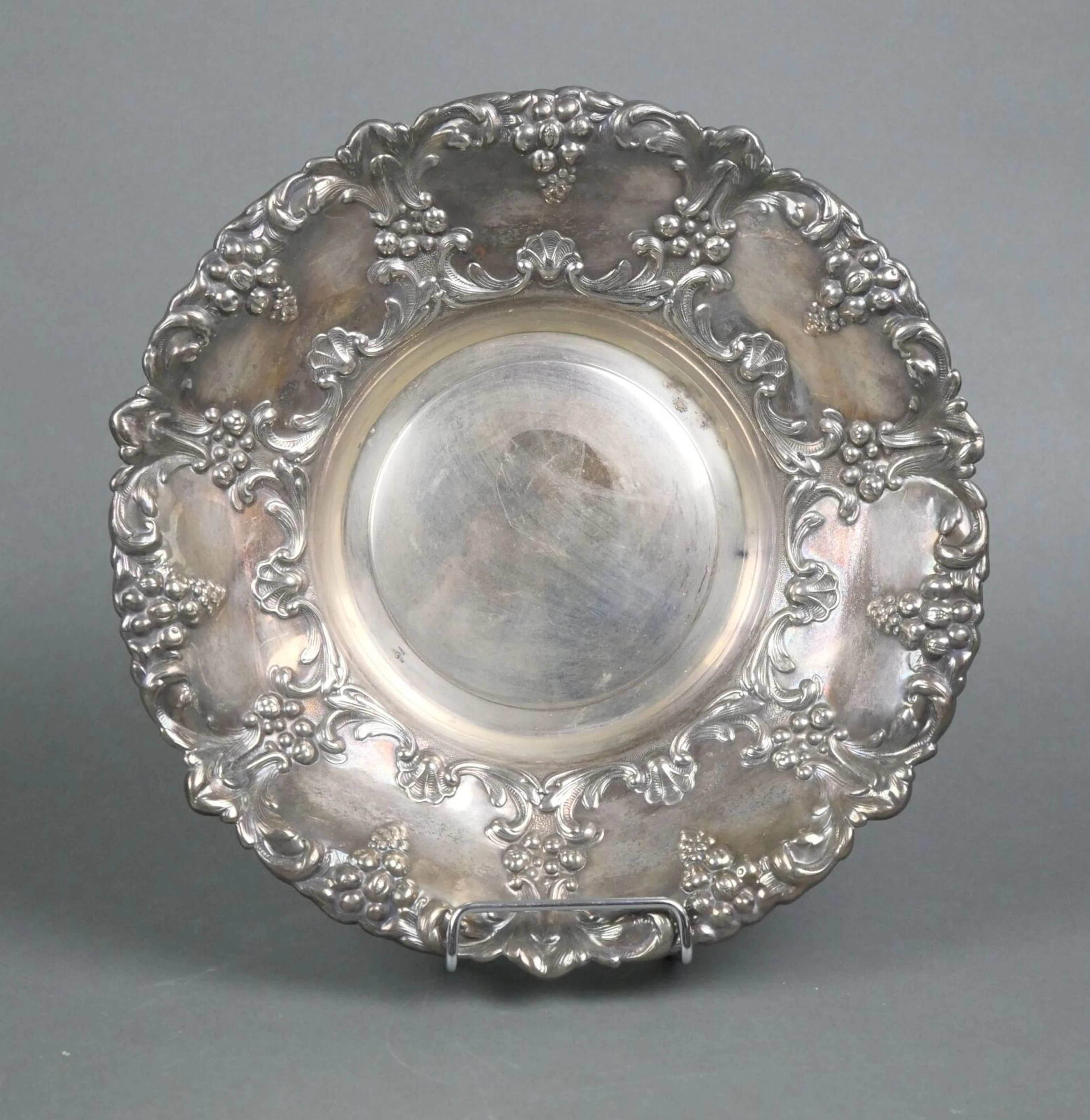 A circular silver plated metal bowl with rich chiseled and r - Lot 132