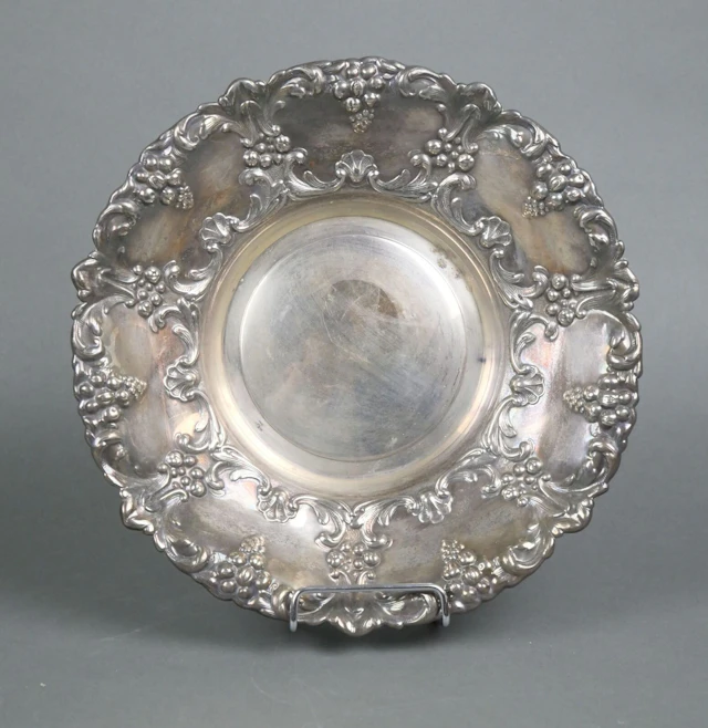 A circular silver plated metal bowl with rich chiseled and r - Lot 132