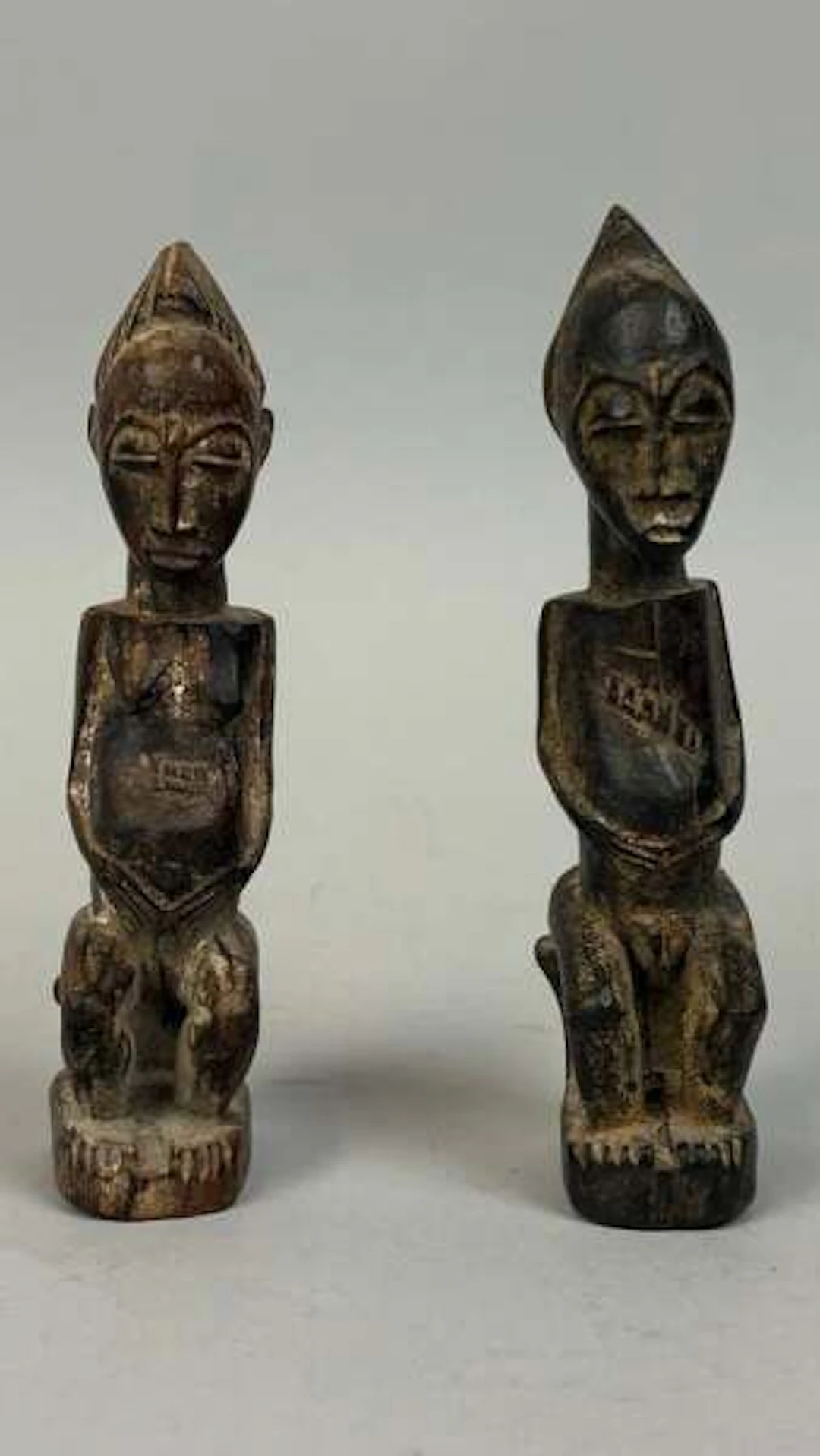 Pair of protective amulets carved from wood with a dark pati - Lot 218