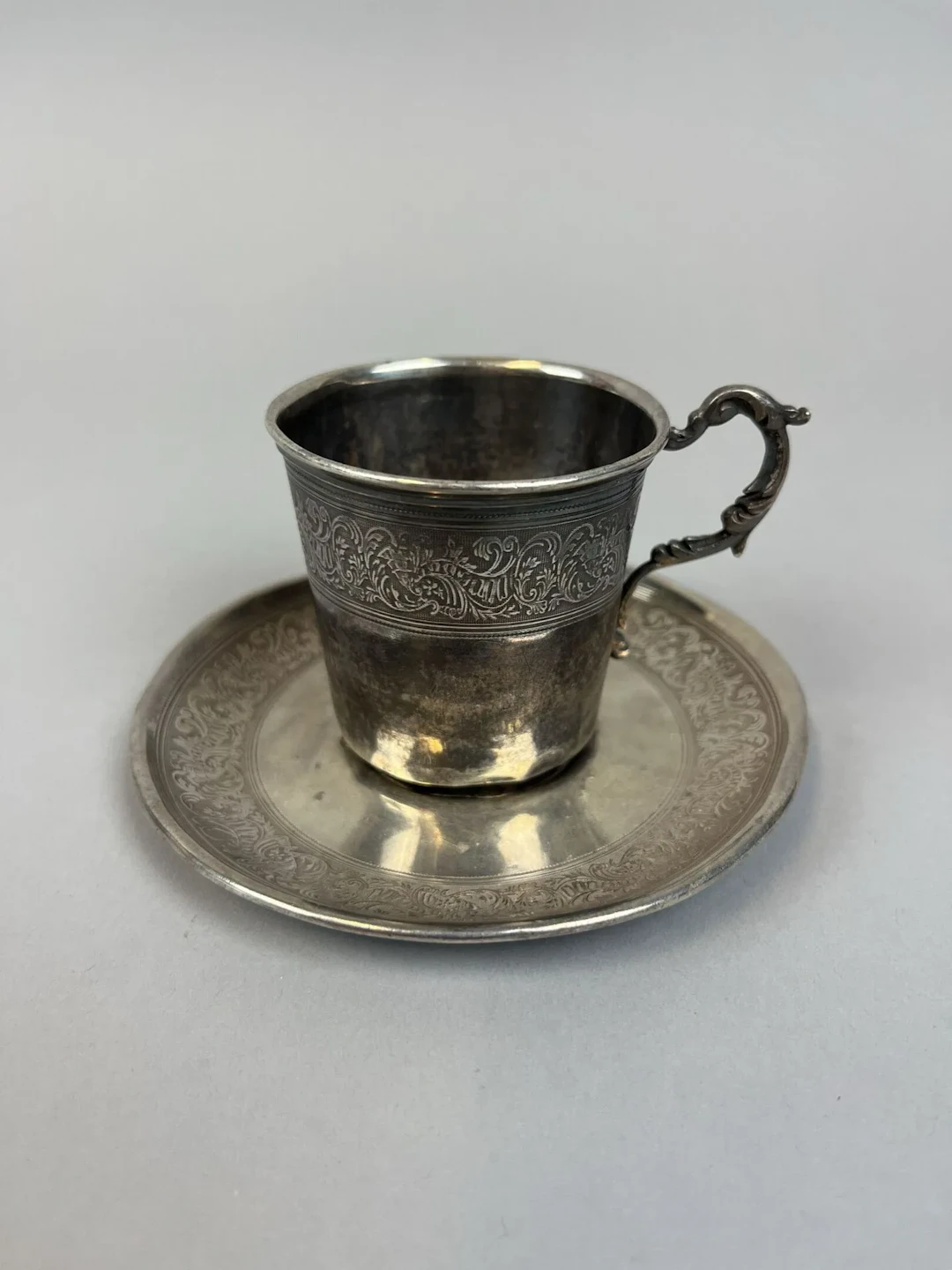 950-thousandths silver cup and saucer with a chased design o - Lot 129