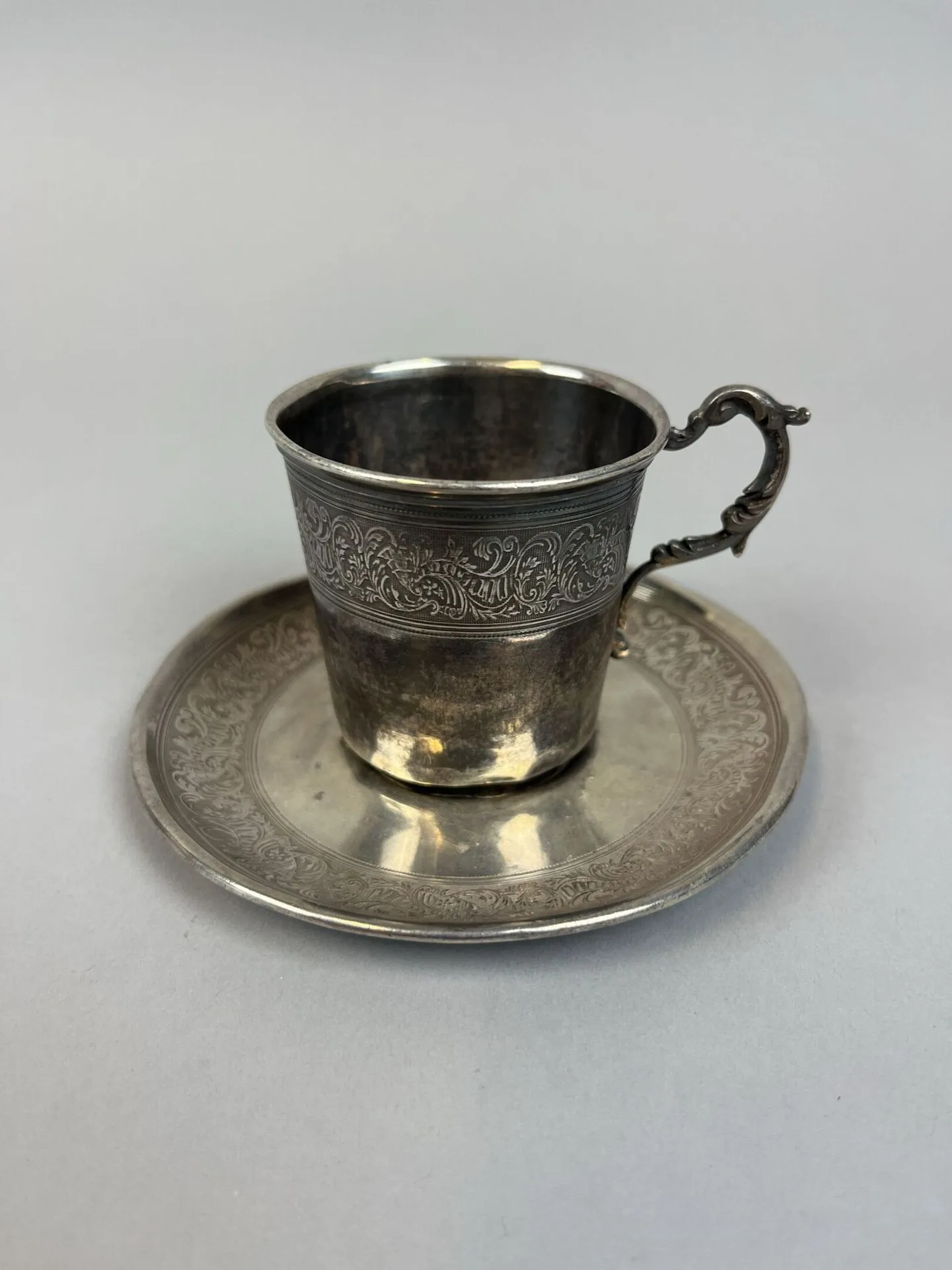 950-thousandths silver cup and saucer with a chased design o - Lot 129