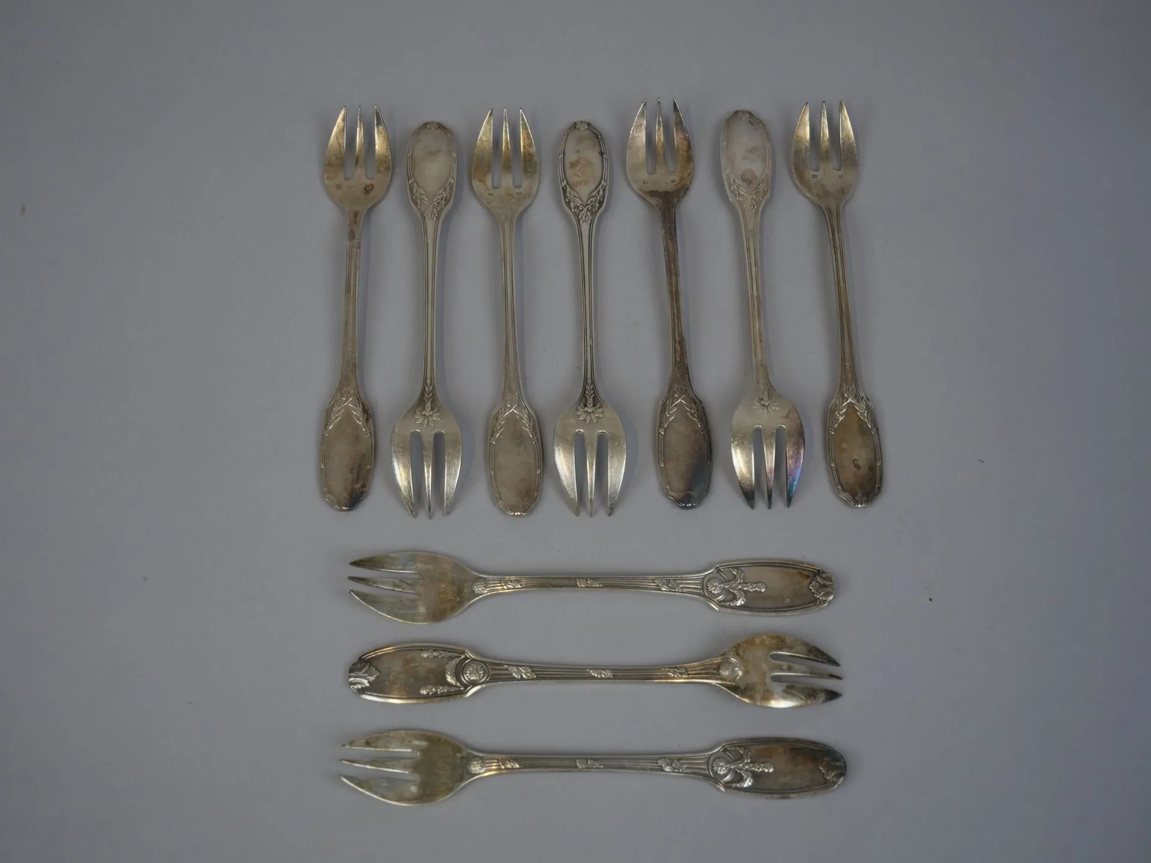 Set of 10 silver plated oyster forks in various designs, dec - Lot 135