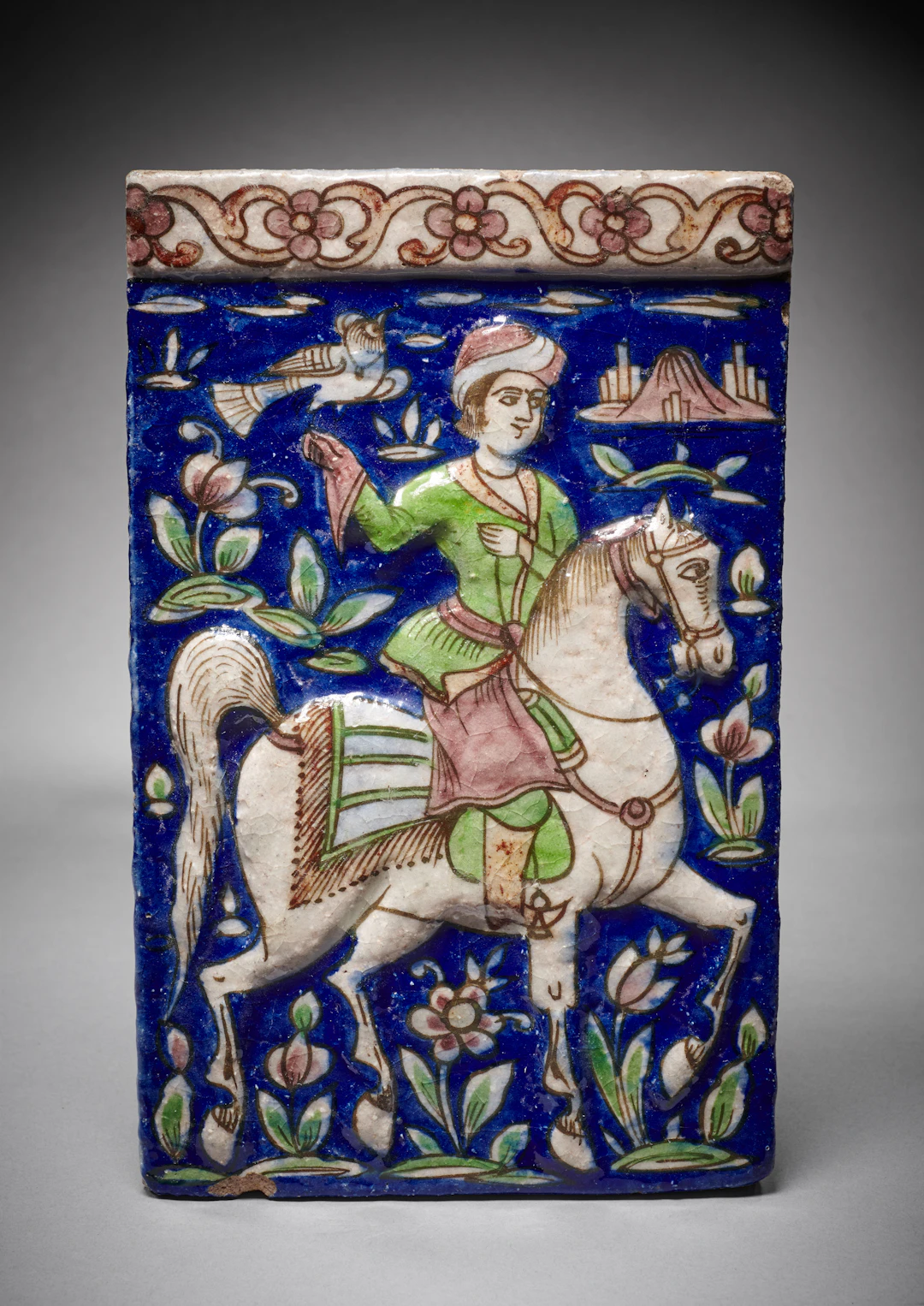 A Qajar Moulded Pottery Tile with a Mounted Falconer