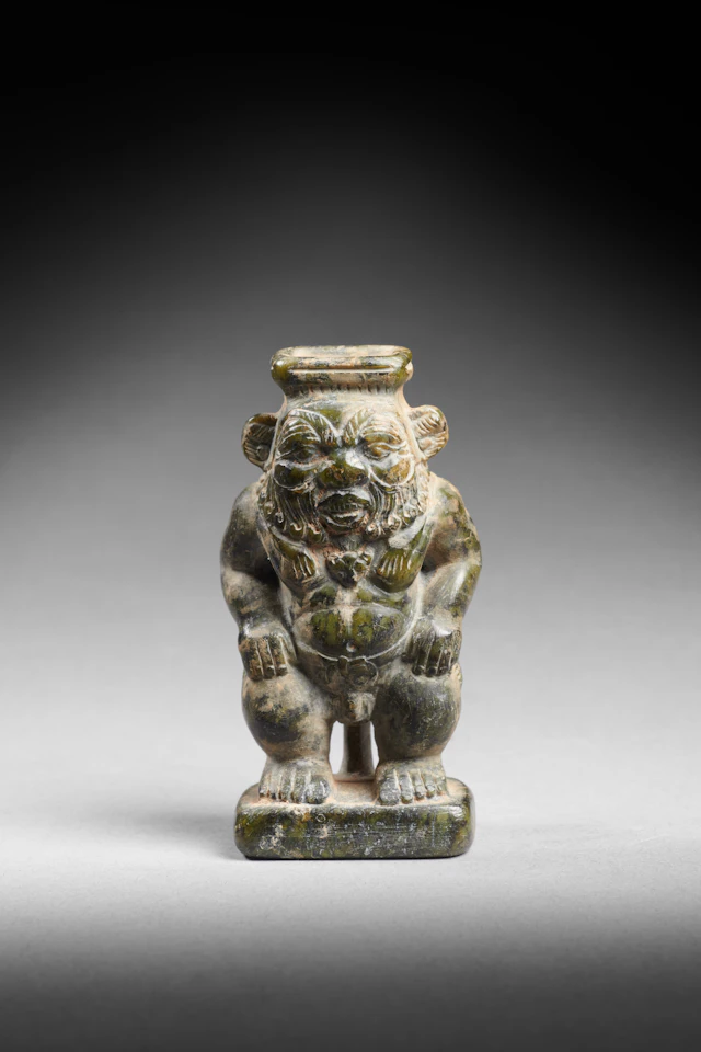 An Egyptian steatite cosmetic jar in the form of the god Bes