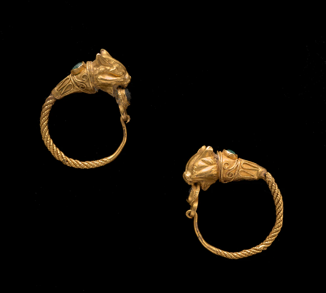 A Hellenistic pair of gold and glass lynx-headed earrings