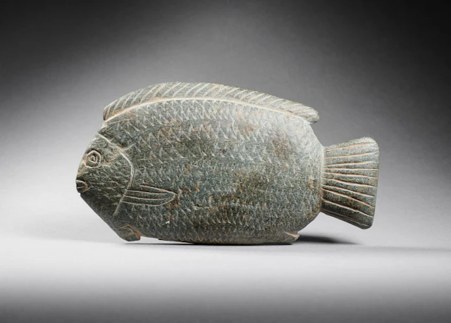 An Egyptian schist cosmetic spoon in the shape of a Tilapia Nilotica fish