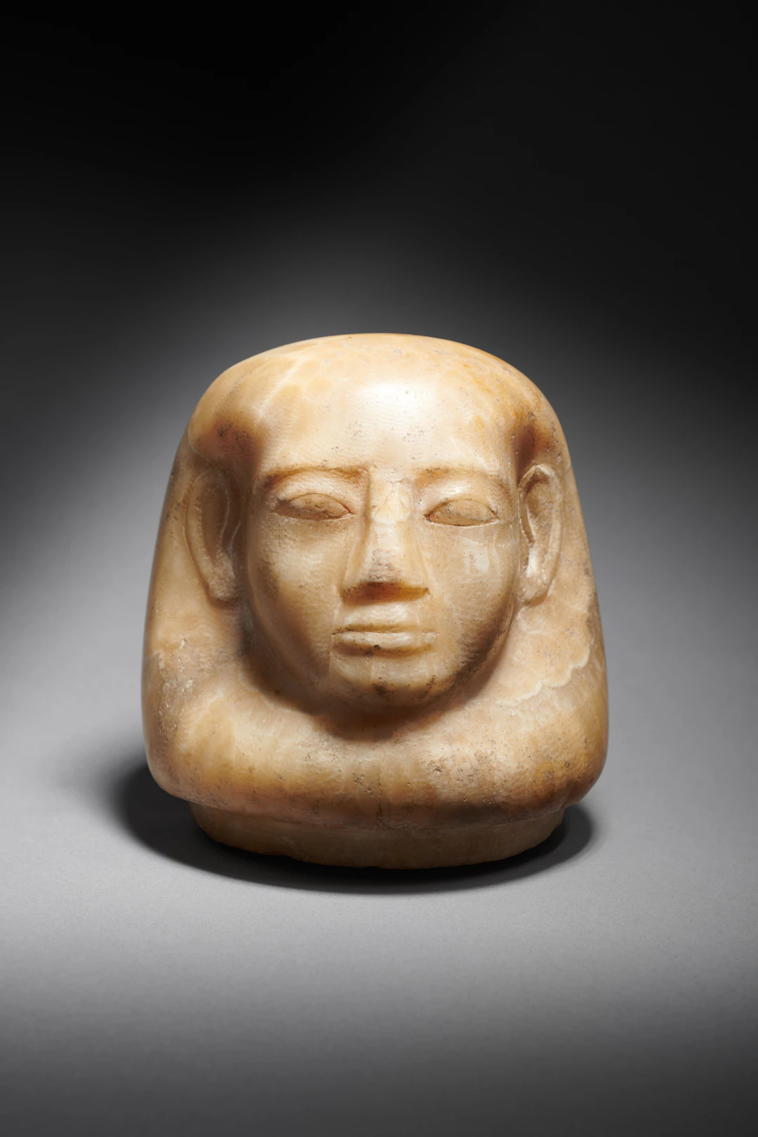 An Egyptian alabaster cork of canopic jar