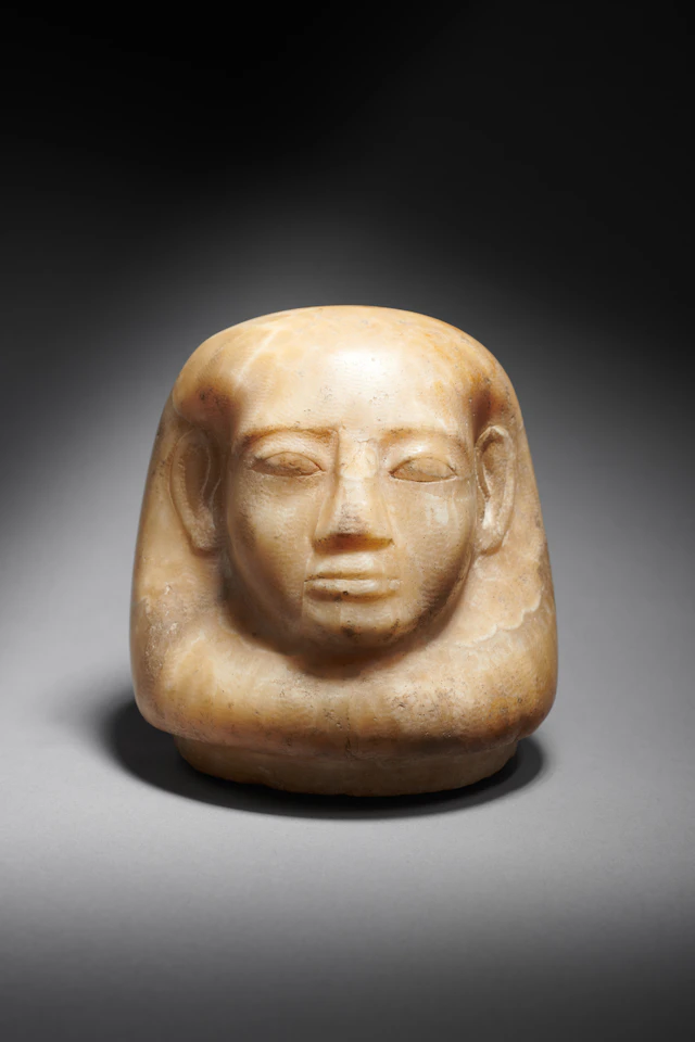 An Egyptian alabaster cork of canopic jar