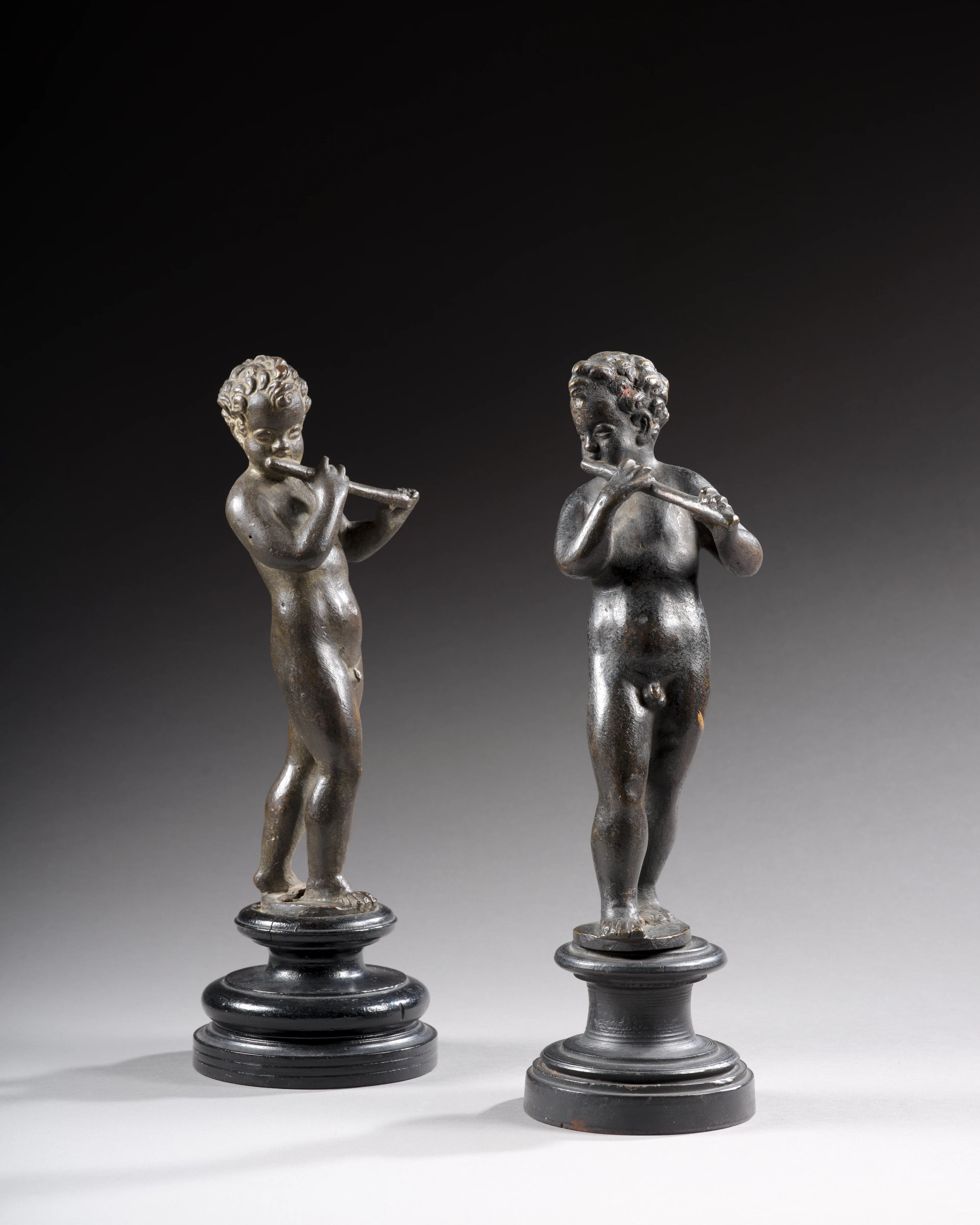DEUX FIGURES EN BRONZE REPRÉSENTANT DES PUTTI JOUANT DE LA FLÛTE