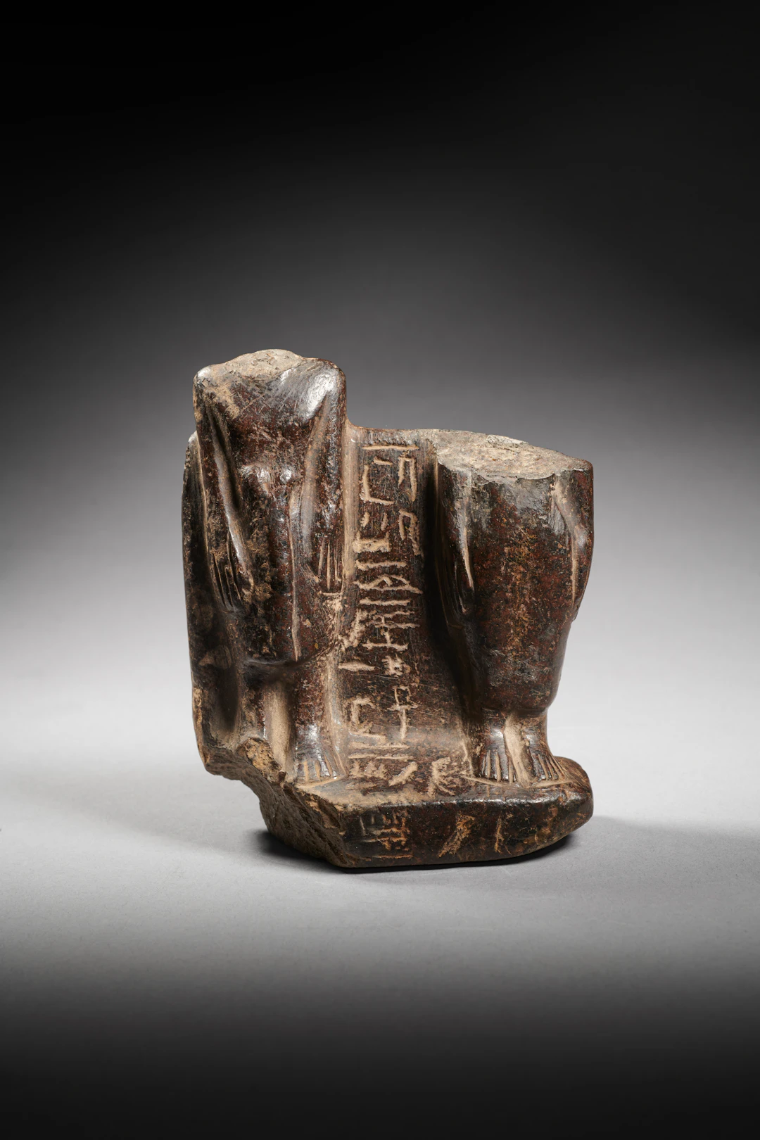 An Egyptian fragmentary basalt statuette of a couple