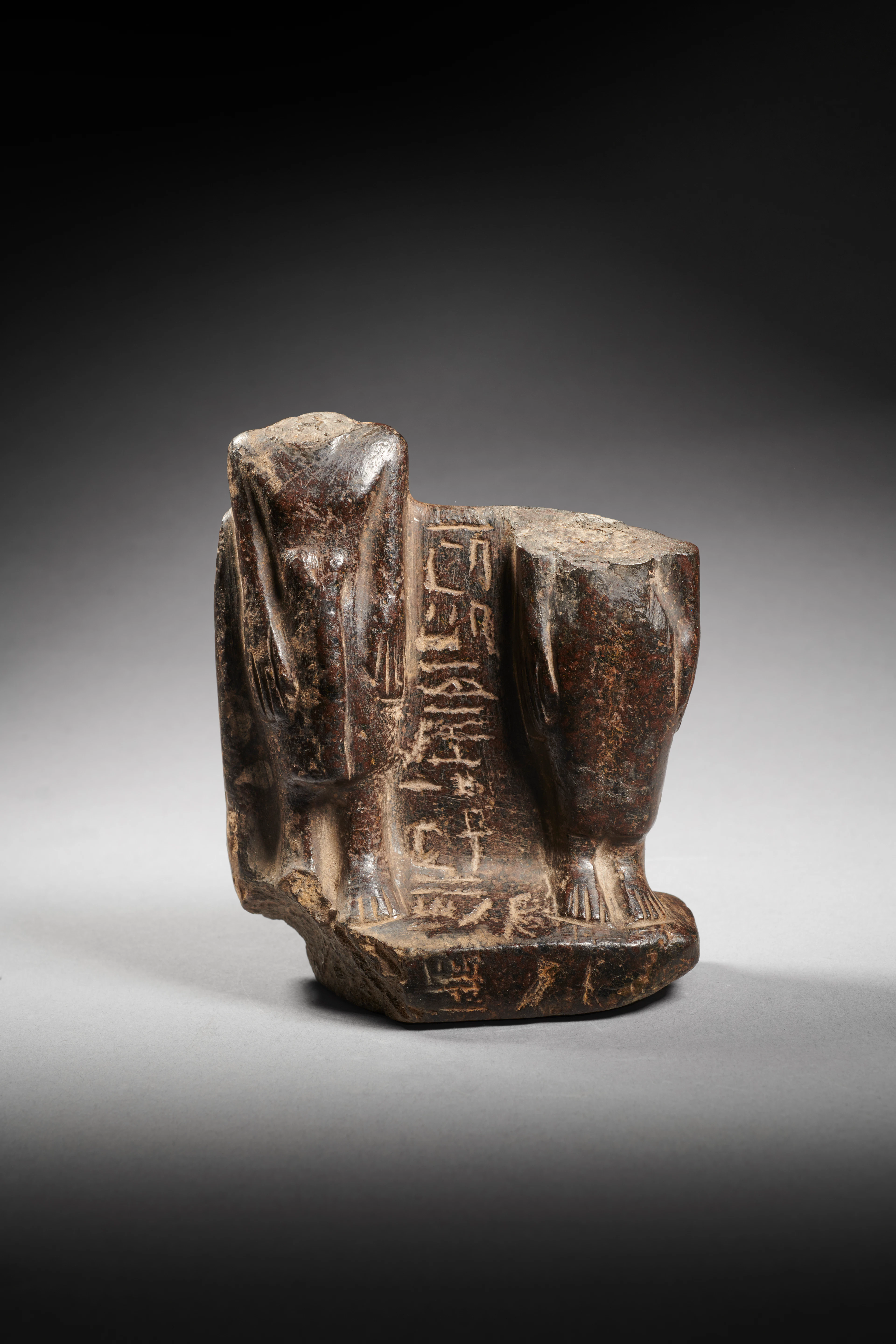 An Egyptian fragmentary basalt statuette of a couple