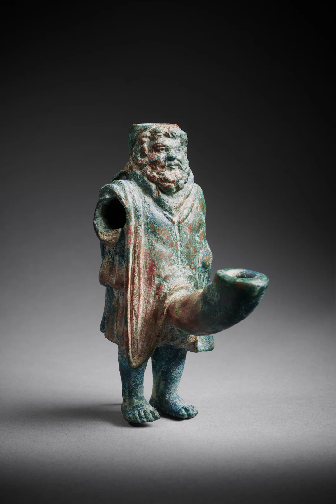 A Roman bronze lamp with the ithyphallic god Priapus
