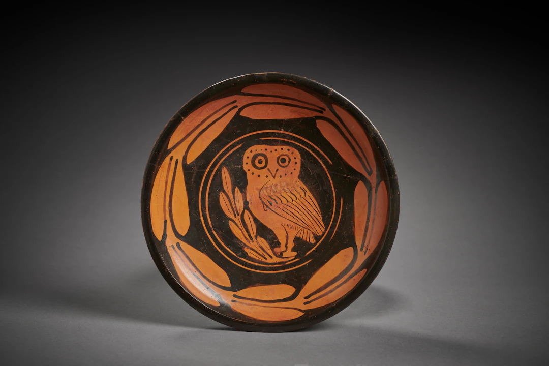 A Greek red-figured plate with an owl