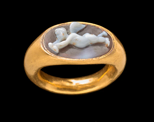 A Roman gold and agate cameo ring with Eros playing an aulos