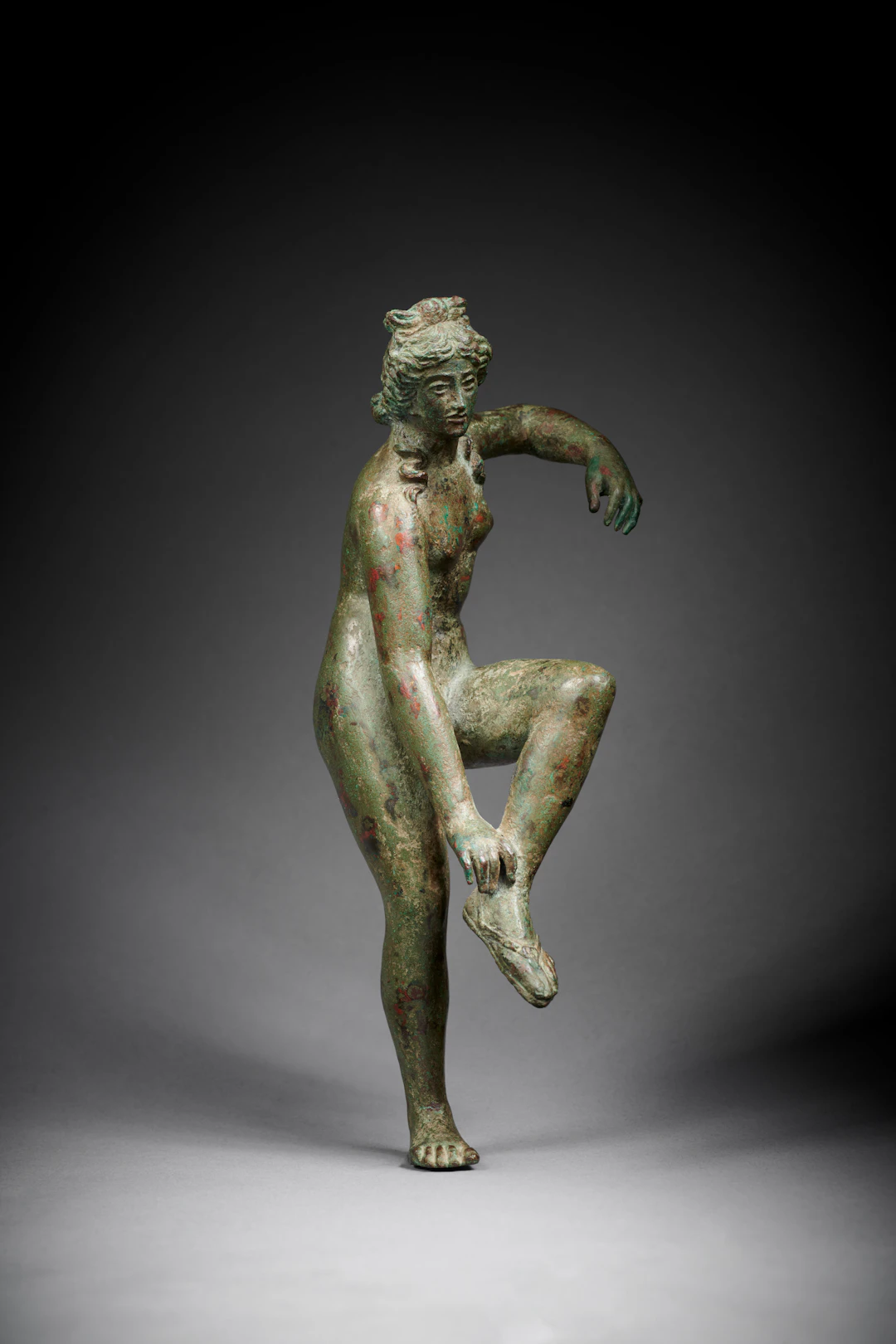 A Roman bronze statuette of Venus loosening her sandal