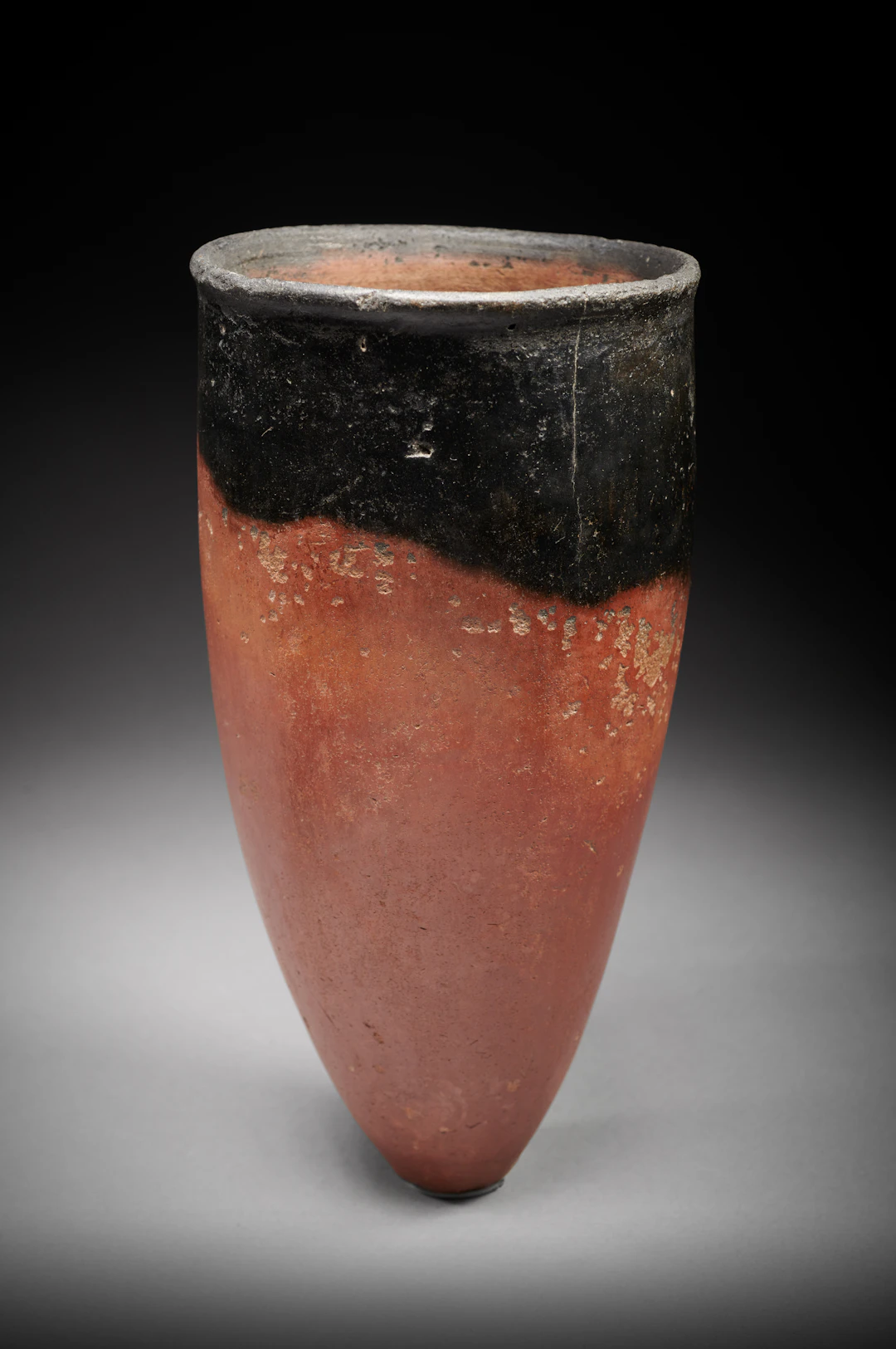 An Egyptian terracotta black-topped vase