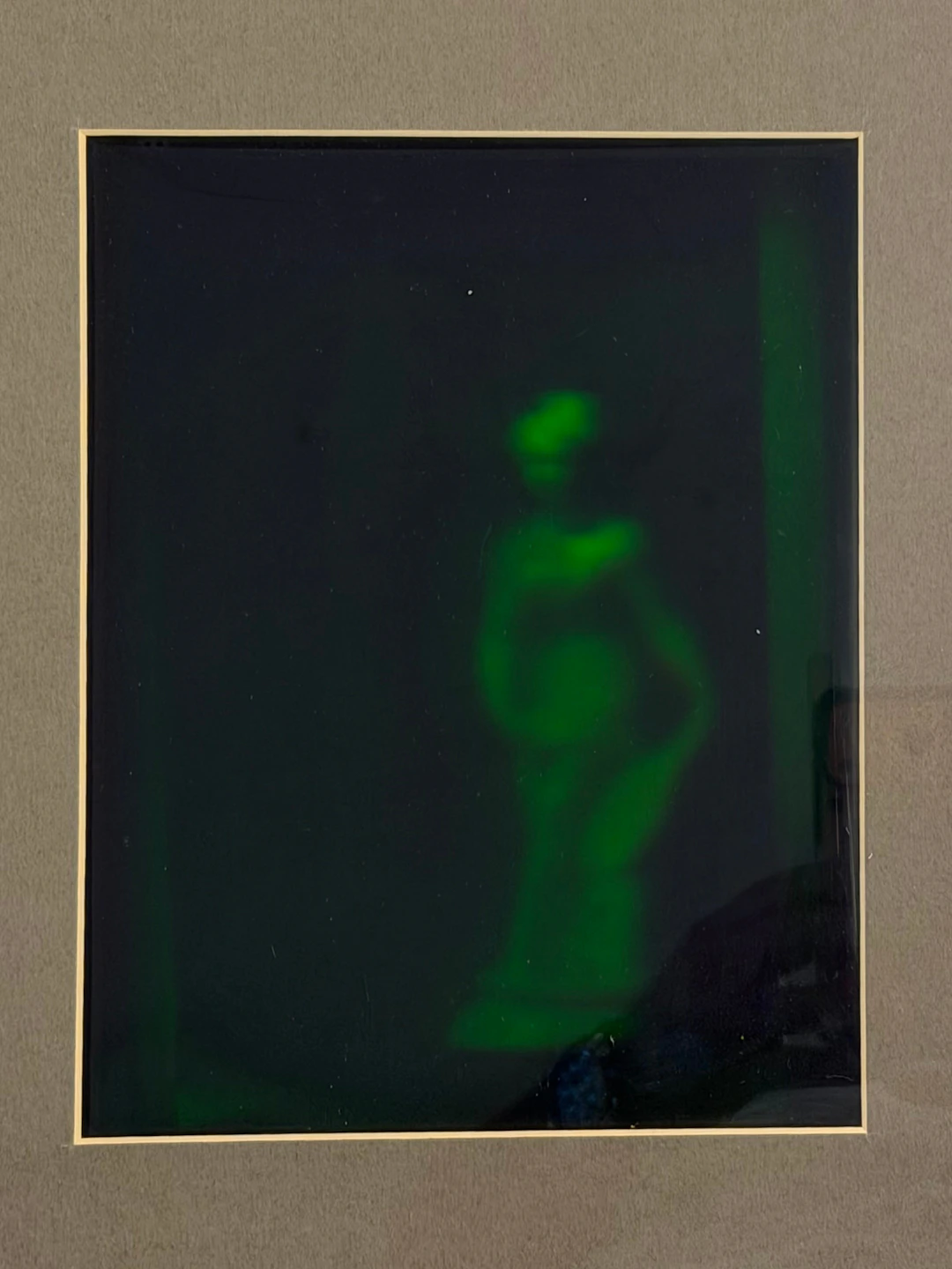 HOLOGRAM, inramat, staty bakom krossat glas.