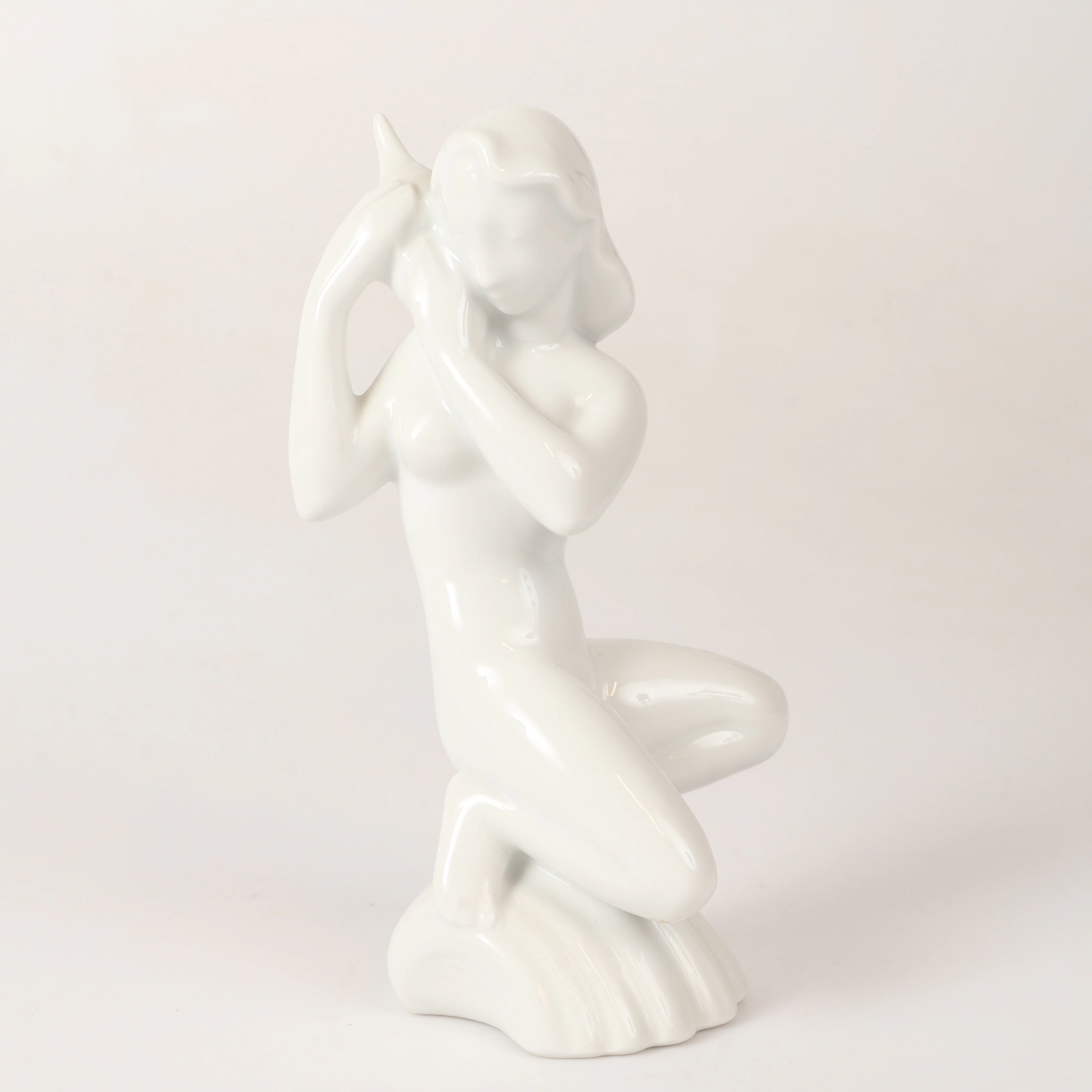 EVA STAEHR NIELSEN (1911-76). Figurin, kvinna med snäcka, porslin