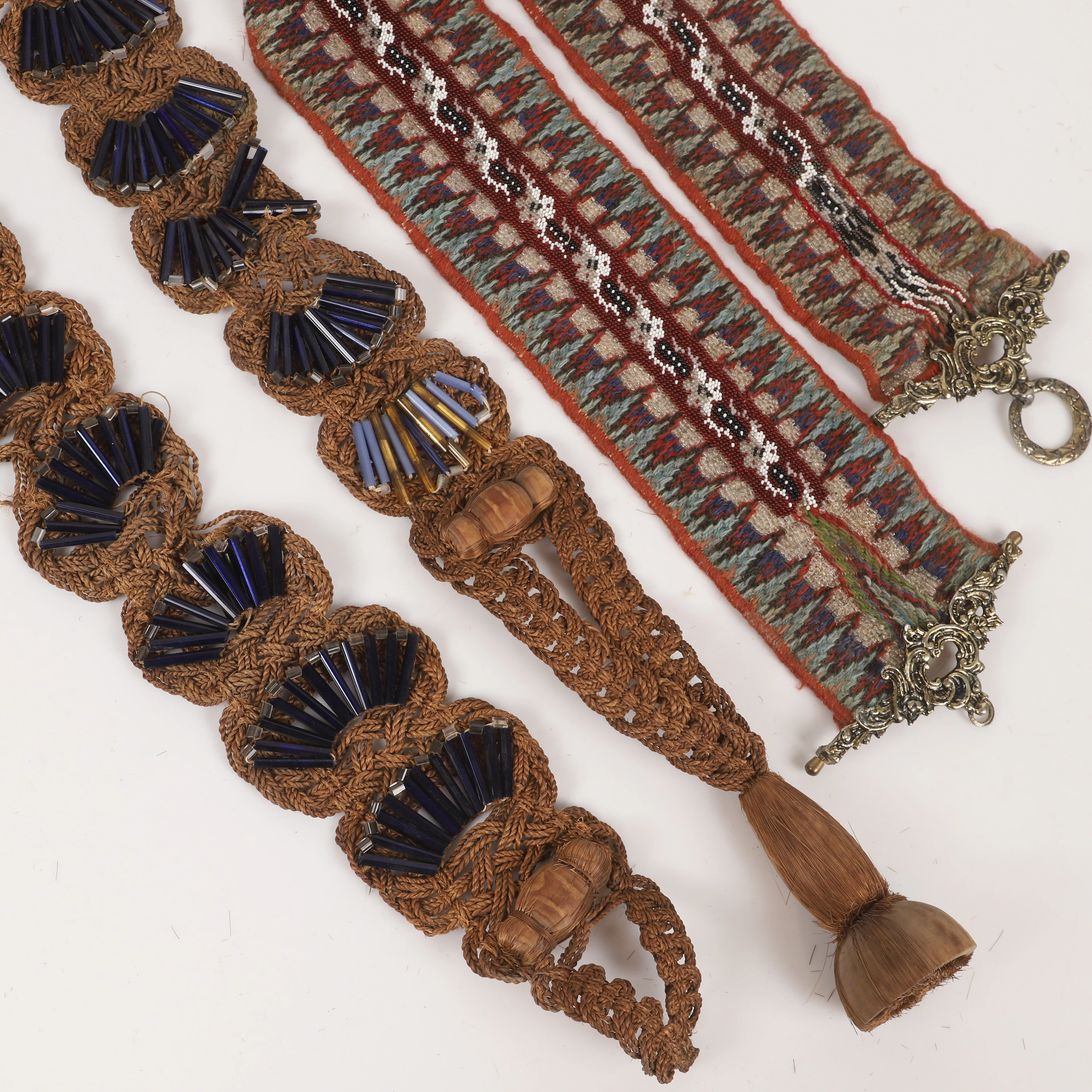 SPJÄLLBAND, 2 stycken, textil/pärlor m. m., tidigt 1900-tal.
