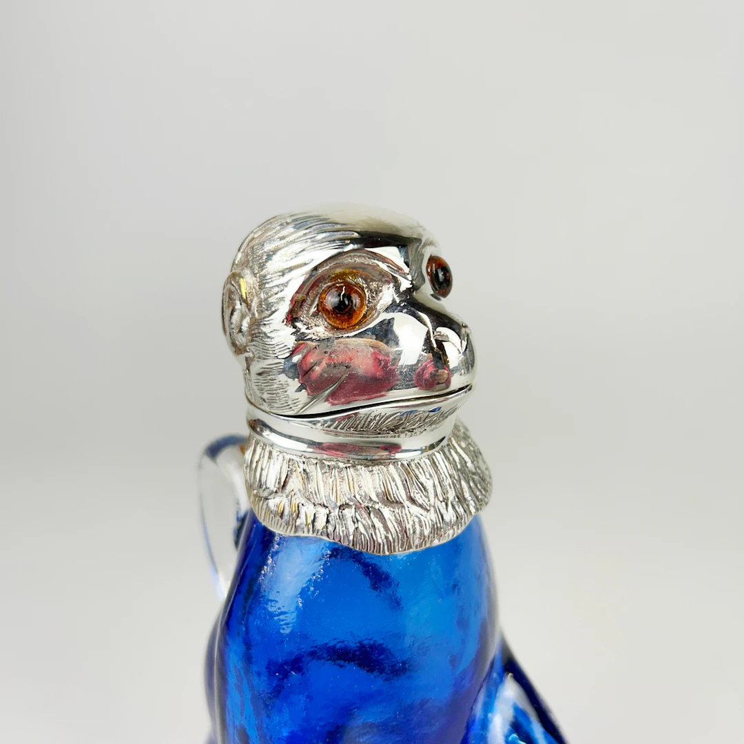 SILVER PLATED & BLUE GLASS MONKEY JUG.