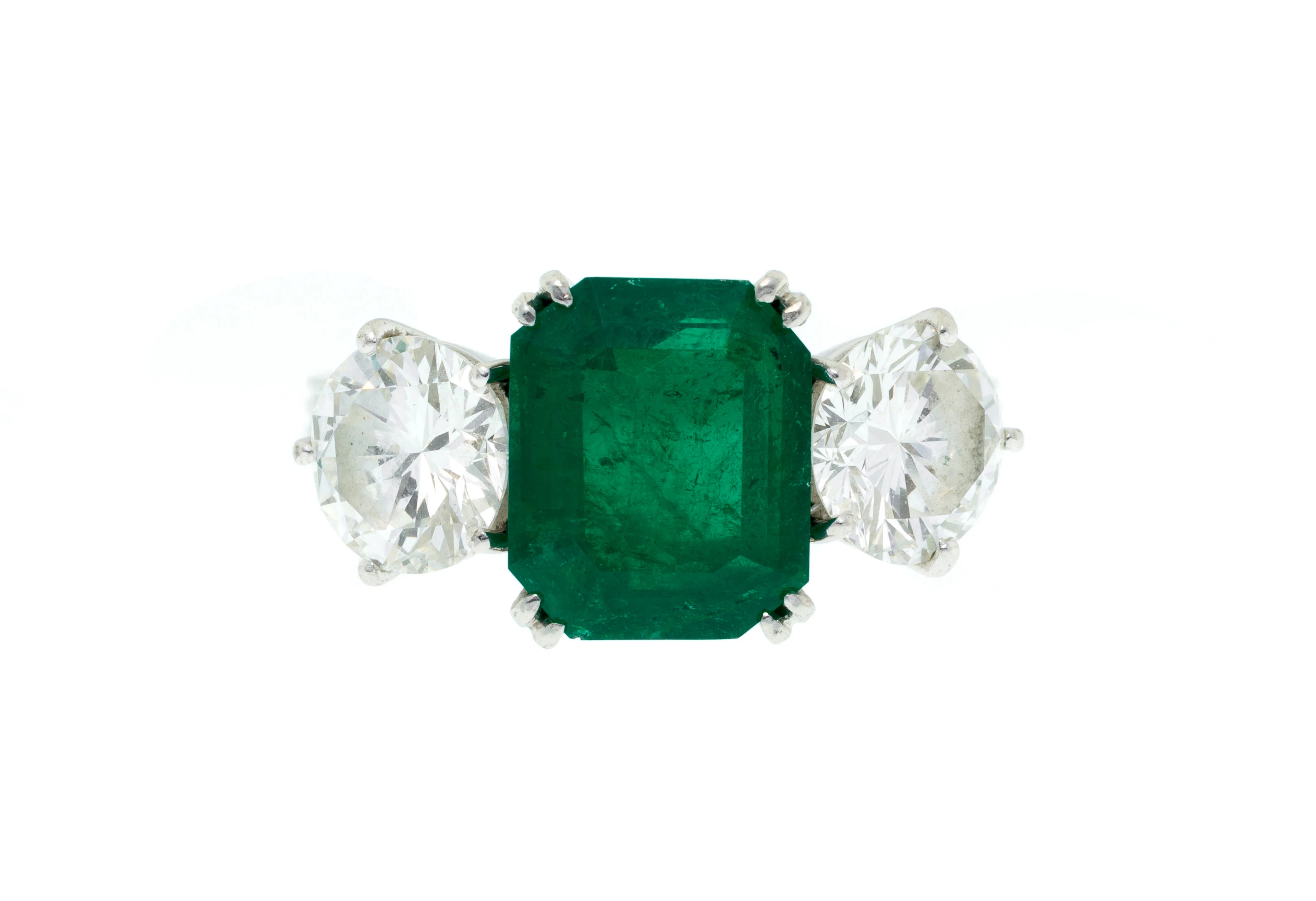 Bague en platine sertie d'une émeraude octogonale épaulée de diamants