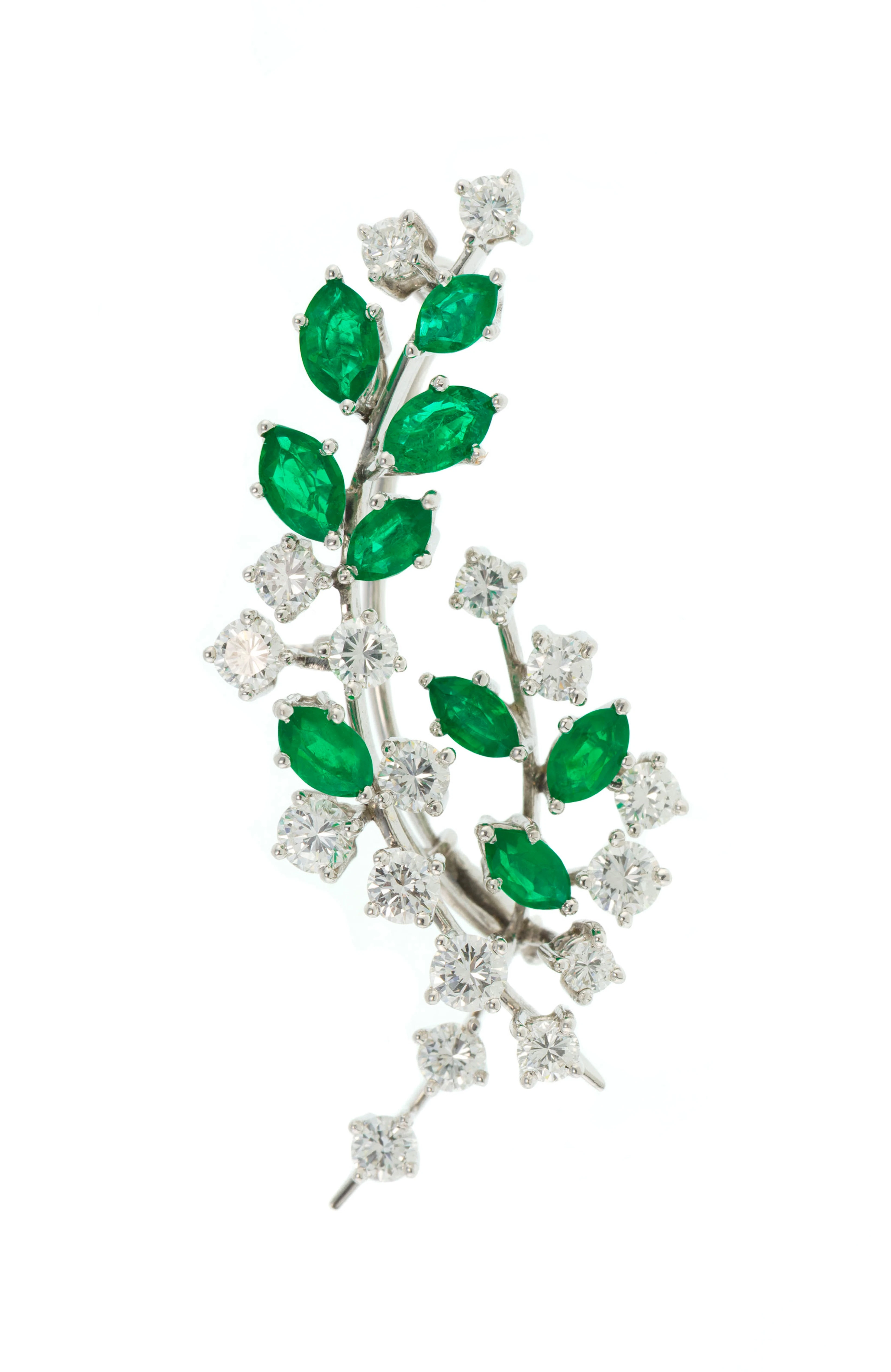 Broche or gris 750 figurant une branche sertie d'émeraudes taille