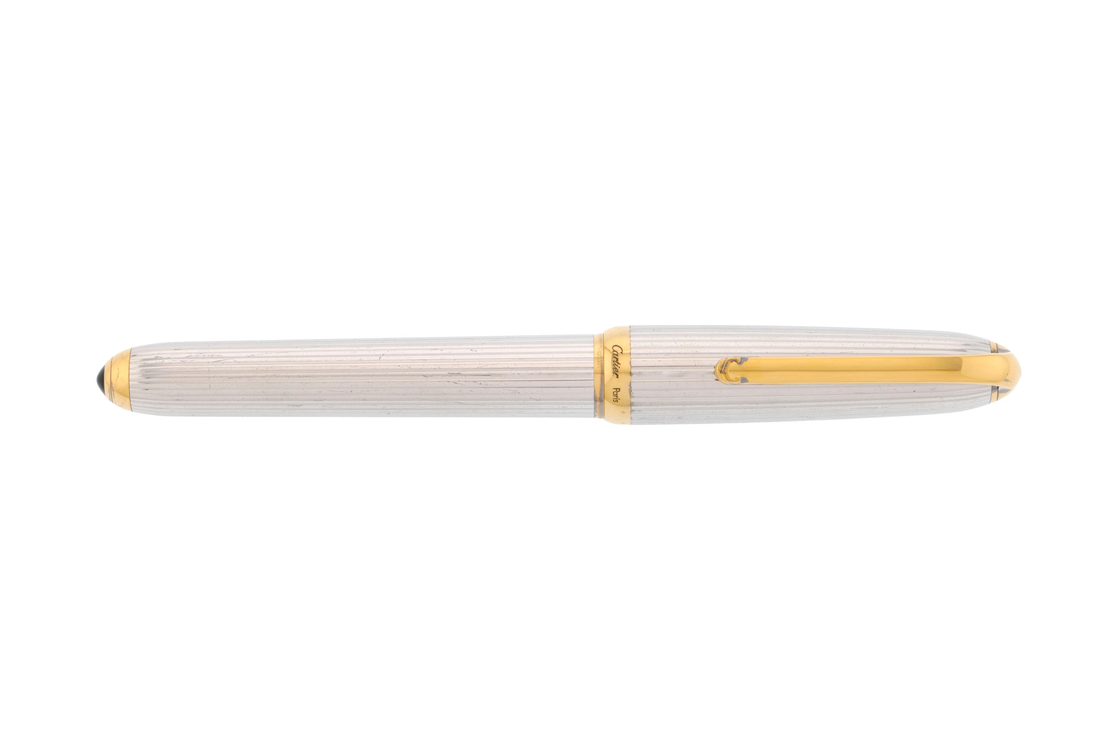 Cartier, un stylo plume en métal doré et argenté godronné orné d'un