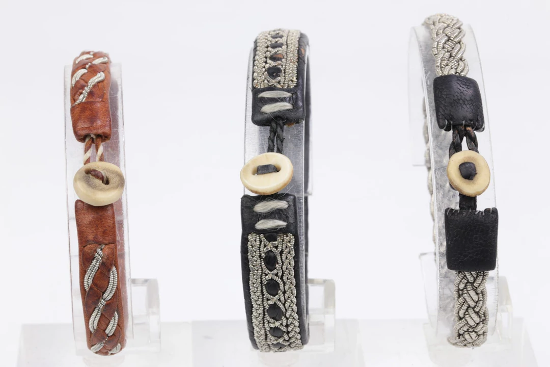ARMBAND, 3 st, samehantverk, skinn med dekor av tennbrodyr och knapp i ben