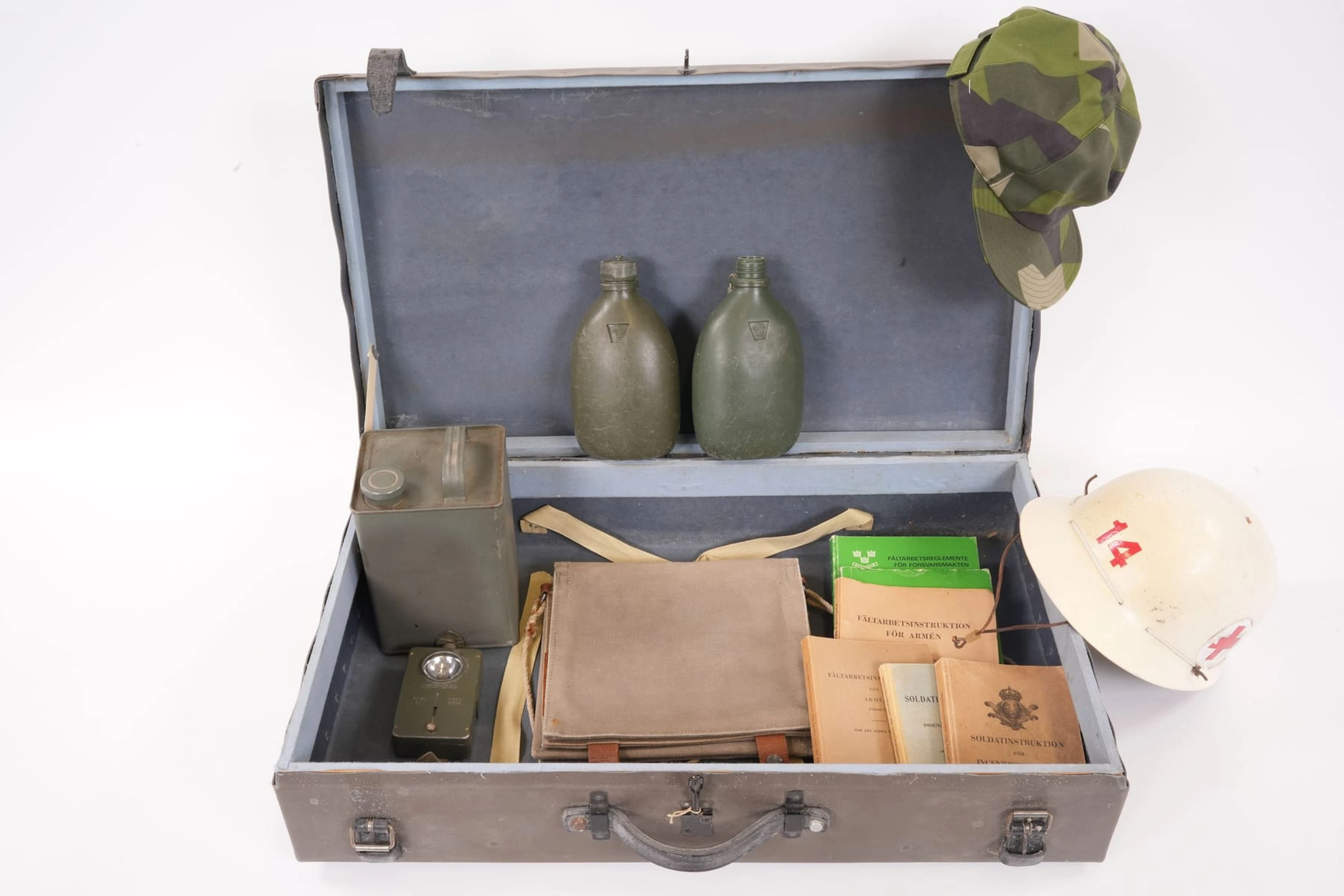 KOFFERT med militaria, bl.a. hjälm, pluntor, böcker